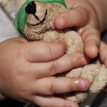 Kind hält einen Teddybären in der Hand